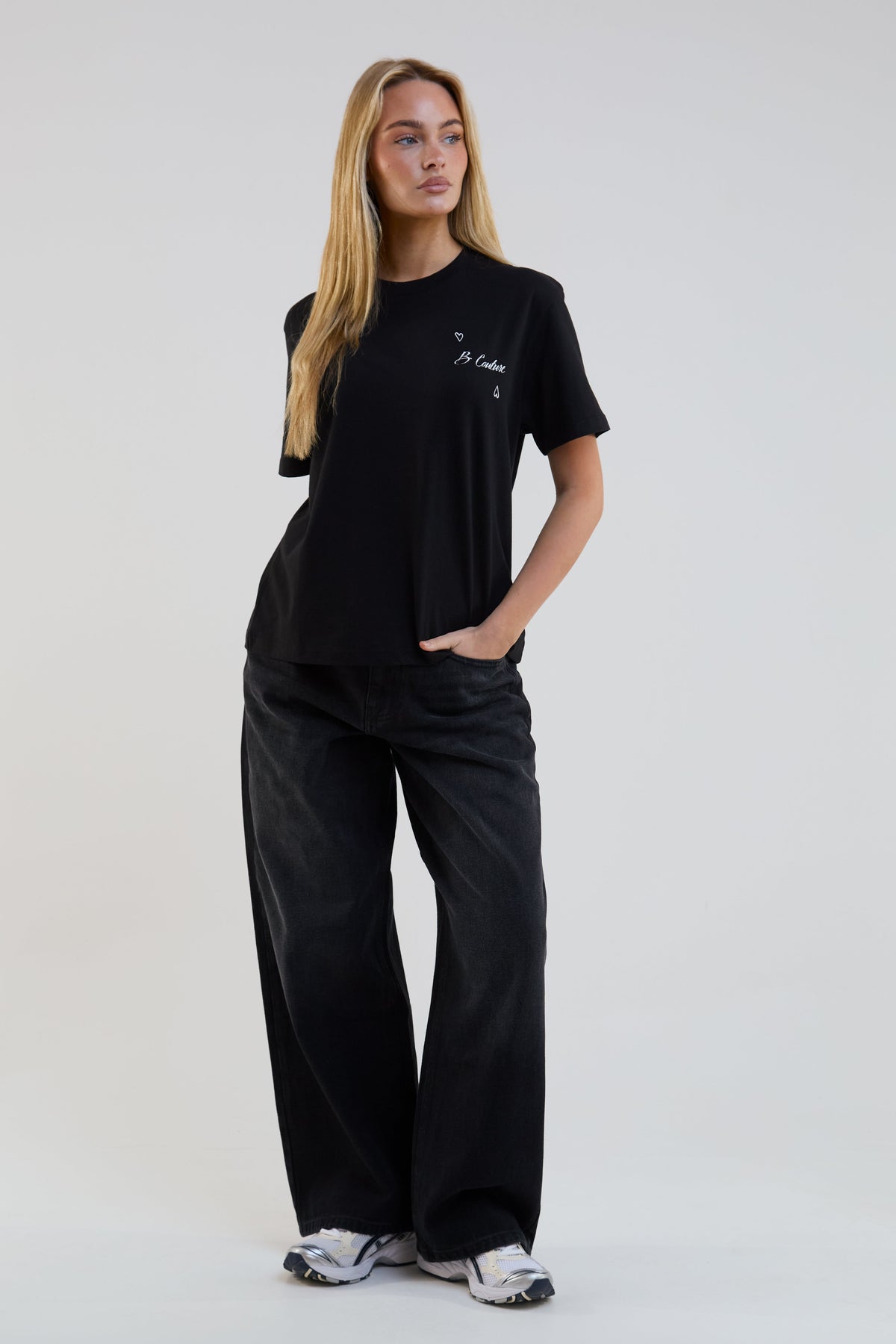 Woman wearing a black t-shirt and pants with a logo on a white background