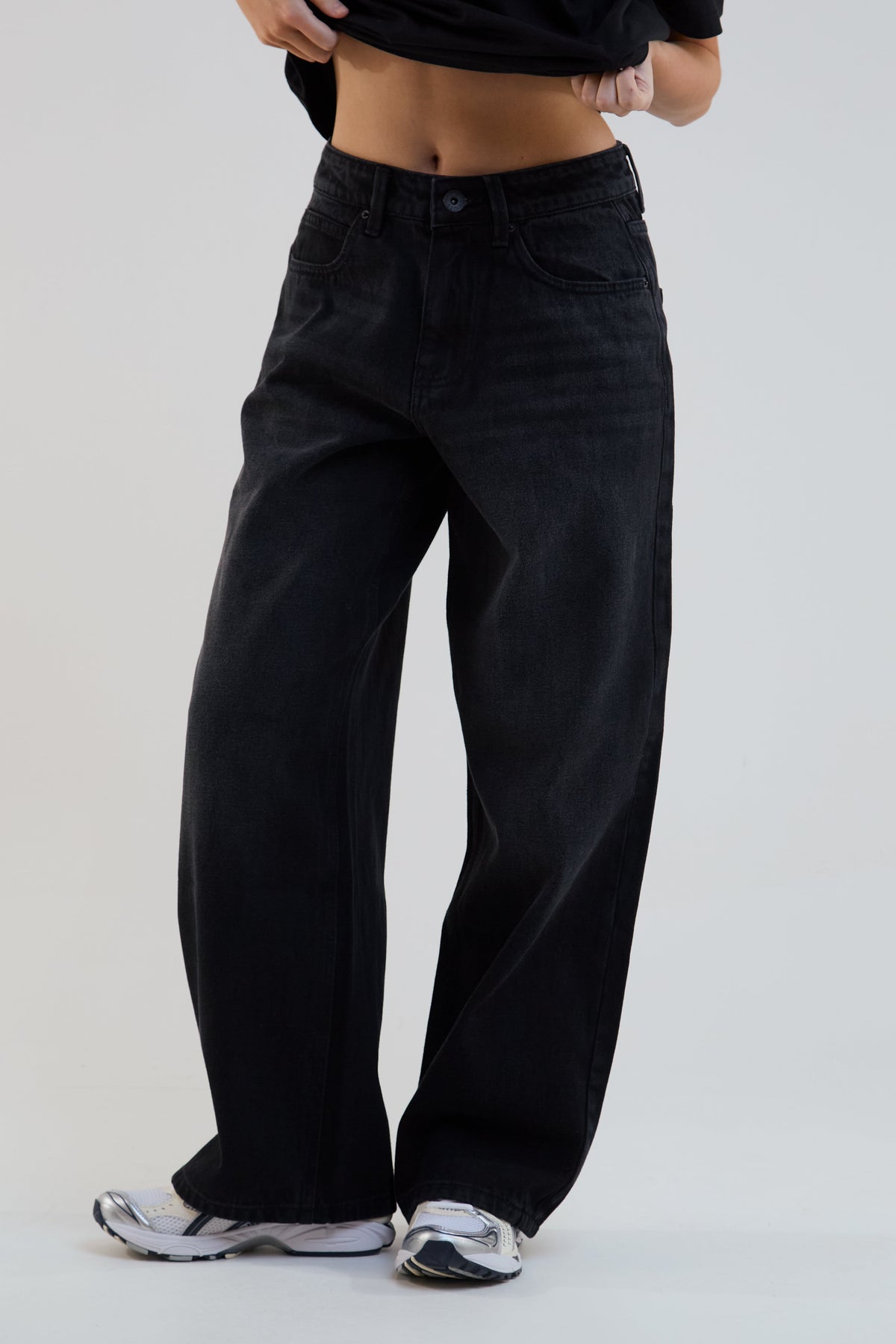 Person wearing black wide-leg pants on a plain background