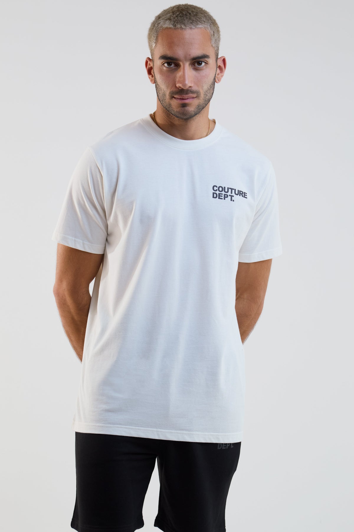 Man wearing a white t-shirt with 'Couture Dept.' text on a plain background
