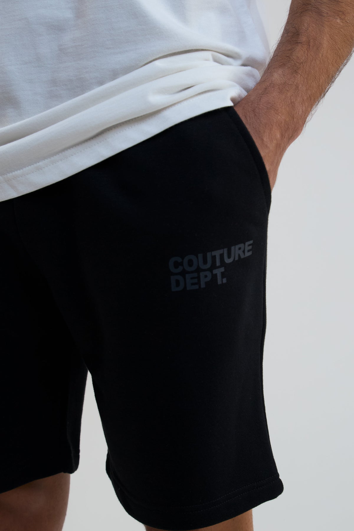 Black shorts with 'COUTURE DEPT.' text on a plain background